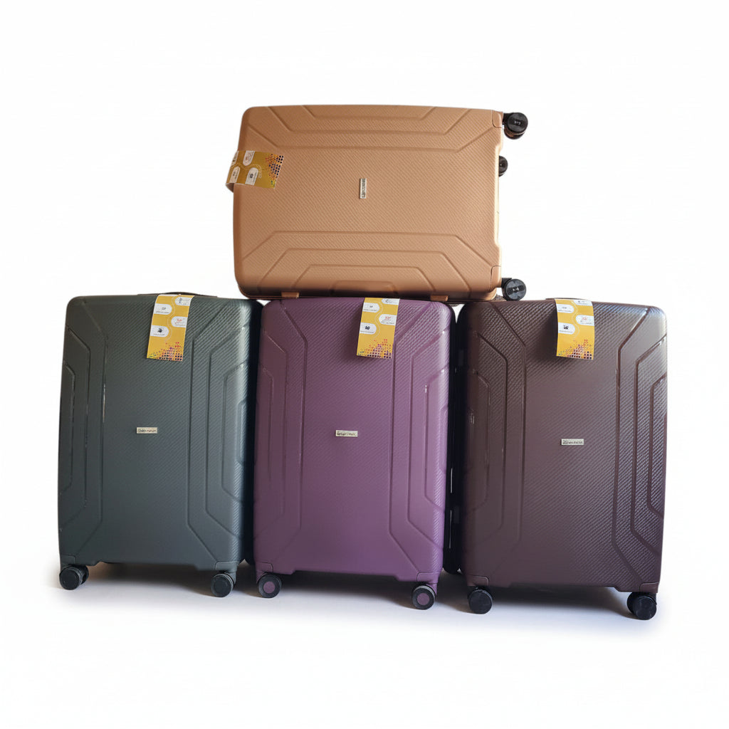 Four suitcases in different colors stacked on a white background